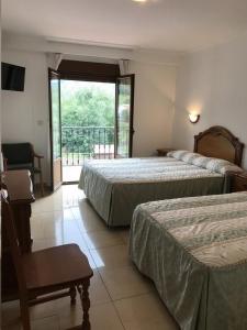 Postel nebo postele na pokoji v ubytování Hotel El Tilo