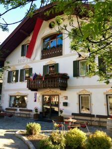 a building with a balcony and tables in front of it at Hotel Holzer in Sesto