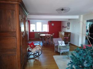 a living room with red walls and a table and chairs at Le Baudinot in Sélestat