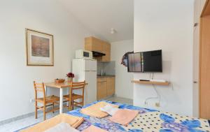 1 dormitorio con cama, mesa y cocina en Apartments Marijan 105 en Pula
