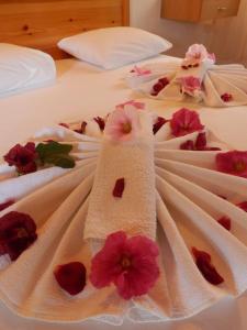 two beds with towels and flowers on them at Dalyan Pension in Dalyan
