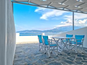 una mesa y sillas con vistas al océano en Epipleon Luxury Suites -104- Δωμάτιο 35τμ με βεράντα 35τμ μπροστά στη θάλασσα, en Nafpaktos
