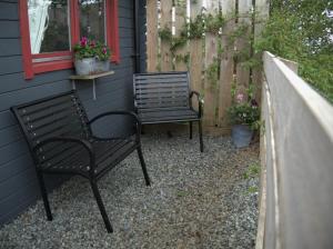 two benches sitting on a patio next to a house at The Cosy Cabin in Portree