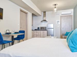 1 dormitorio con 1 cama, mesa y sillas en Epipleon Luxury Suites -104- Δωμάτιο 35τμ με βεράντα 35τμ μπροστά στη θάλασσα, en Nafpaktos