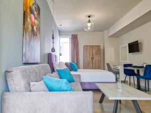 Habitación de hotel con cama y sofá en Epipleon Luxury Suites -104- Δωμάτιο 35τμ με βεράντα 35τμ μπροστά στη θάλασσα, en Nafpaktos