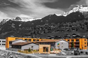 a group of buildings in front of a mountain at Eiger Lodge Easy in Grindelwald