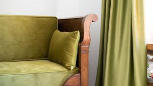a chair with a green pillow next to a window at Italianway - Villa Tola in Valdisotto