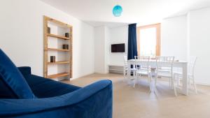 a living room with a blue couch and a table at Italianway - Villa Tola in Valdisotto