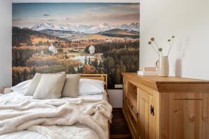 Apartamenty na wzgórzu APARTZAKOP في كوشتيليسكا: غرفة نوم بسرير وجدارية جبلية
