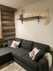 ein Wohnzimmer mit einem Sofa und einem Schild an der Wand in der Unterkunft Revontuli 6 in Syöte