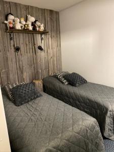 Un dormitorio con dos camas y una pared de madera. en Revontuli 6, en Syöte