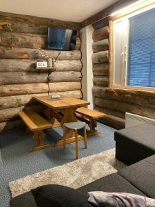Habitación con pared de madera, mesa y TV. en Revontuli 6, en Syöte