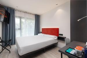 a bedroom with a large bed and a table at Arena Zone Hotel in Valencia