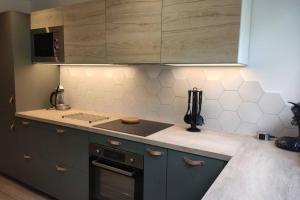 cocina con armarios grises y horno con fogones en Appartement 3 chambres, 3 salles d'eau, en Saint-Herblain 8 fotos más