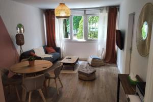 uma sala de estar com uma mesa e um sofá em Appartement 3 chambres, 3 salles d'eau em Saint-Herblain