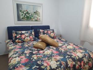 a bed with two pillows and a floral comforter at EILAT GOLF RESIDENCE Apartment A 1 in Eilat +61 photos