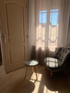 sala de estar con sofá, mesa y puerta en Hotel du Centre - Restaurant le P'tit Gourmet, en Tonnerre