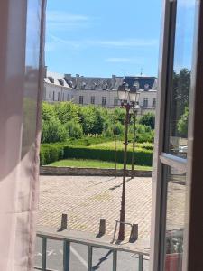 una ventana con vistas a una luz de la calle en Hotel du Centre - Restaurant le P'tit Gourmet en Tonnerre