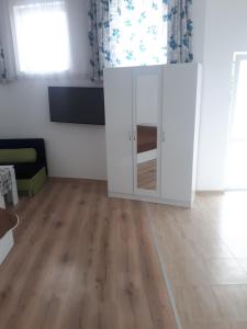 sala de estar con armario blanco y suelo de madera en студия ЛИЛИЯ, en Tsarevo