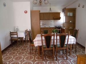 a dining room with a table and chairs and a kitchen at Apartment Kampor 10 in Kampor