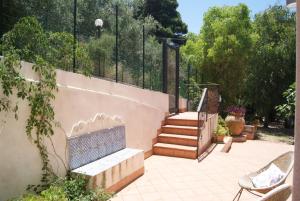 a patio with stairs and a bench next to a wall at Gibilrossa BeeHill in Misilmeri