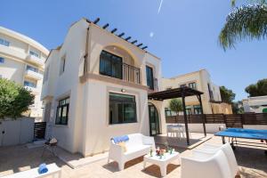a house with a patio and a table and chairs at Mylos 9 in Protaras
