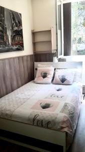 a bedroom with a bed with the words love on it at Appartement Mimosa, tram 2, parking in Montpellier