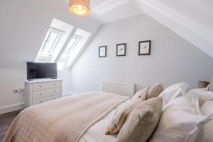1 dormitorio blanco con 1 cama y TV en Geoff's Rest at Pond Hall Farm in Hadleigh with Private Hot Tub, en Ipswich