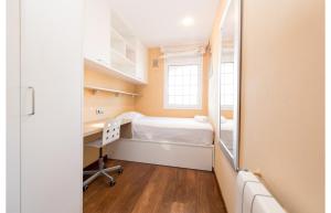 a room with a bed and a desk and a mirror at HomeHolidaysRentals Royal in Pineda de Mar