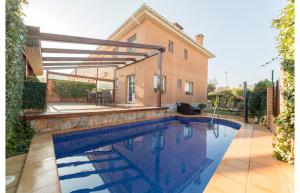 a swimming pool in front of a house at HomeHolidaysRentals Royal in Pineda de Mar