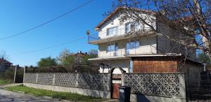 a white house with a fence in front of it at Krimski Guest House and Bungalows in Byala