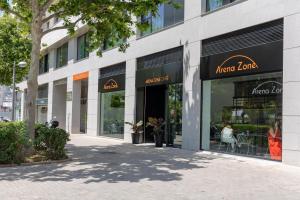 Arena Zone Hotel في فالنسيا: متجر أمام مبنى به العديد من النوافذ