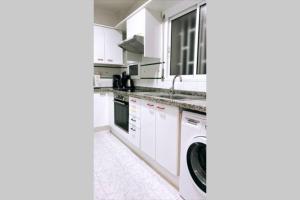 una cocina blanca con una lavadora dentro en Apartamento VISTA MAR, en Salou 10 fotos más