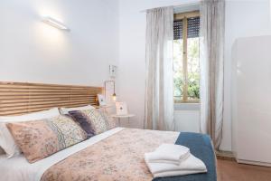 a bedroom with a bed with pillows and a window at Interno 6 San Pietro in Rome