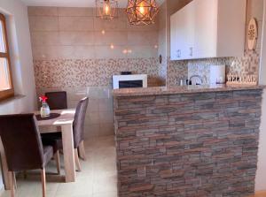 a kitchen with a table and a brick wall at Planinska kuca za odmor-Mlinista in Landeke