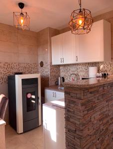 a kitchen with white cabinets and a stove top oven at Planinska kuca za odmor-Mlinista in Landeke