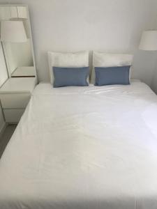 セトゥーバルにあるCasa da Avenida IIの白い大型ベッド(青い枕2つ付)