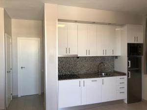 kuchnia z białymi szafkami i zlewem w obiekcie COSTA DAURADA APARTAMENTS - Stival Park 4 w mieście La Pineda
