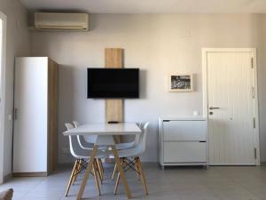 pokój ze stołem, krzesłami i telewizorem w obiekcie COSTA DAURADA APARTAMENTS - Stival Park 4 w mieście La Pineda