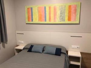 sypialnia z łóżkiem z 2 poduszkami i obrazem w obiekcie COSTA DAURADA APARTAMENTS - Stival Park 4 w mieście La Pineda +21 zdjęć