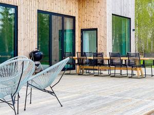 eine Gruppe Stühle und ein Tisch auf einer Terrasse in der Unterkunft 9 person holiday home in H CKSVIK in Håcksvik