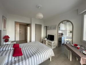 a bedroom with a large bed and a red chair at Studio Terrasse in Cannes