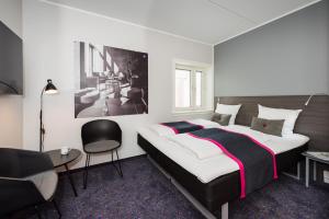 a hotel room with a large bed and a large window at Cabinn Odense in Odense