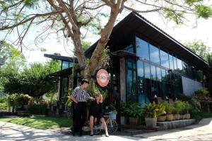 a man and a woman standing in front of a building at Family House Zen Boutique Resort in Pai