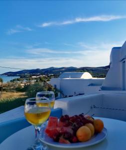 un piatto di frutta e un bicchiere di vino su un tavolo di ThalaSEA - village Antiparos a Città di Antiparo