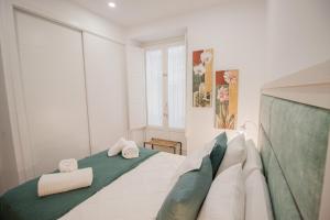 1 dormitorio con 1 cama con toallas en Casa Urquinaona, en Cádiz