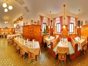 a restaurant with tables and chairs in a room at Gasthof Alter Wirt in Bernau am Chiemsee