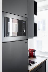 einen Kühlschrank in einer Küche mit einer Mikrowelle in der Unterkunft LES PIEDS DANS LE VIEUX PORT in Marseille