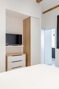 1 dormitorio con 1 cama y TV en la pared en LES PIEDS DANS LE VIEUX PORT en Marsella