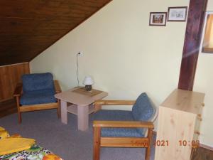 Zimmer mit 2 Stühlen, einem Tisch und einem Bett in der Unterkunft Privat Alena in Harrachov